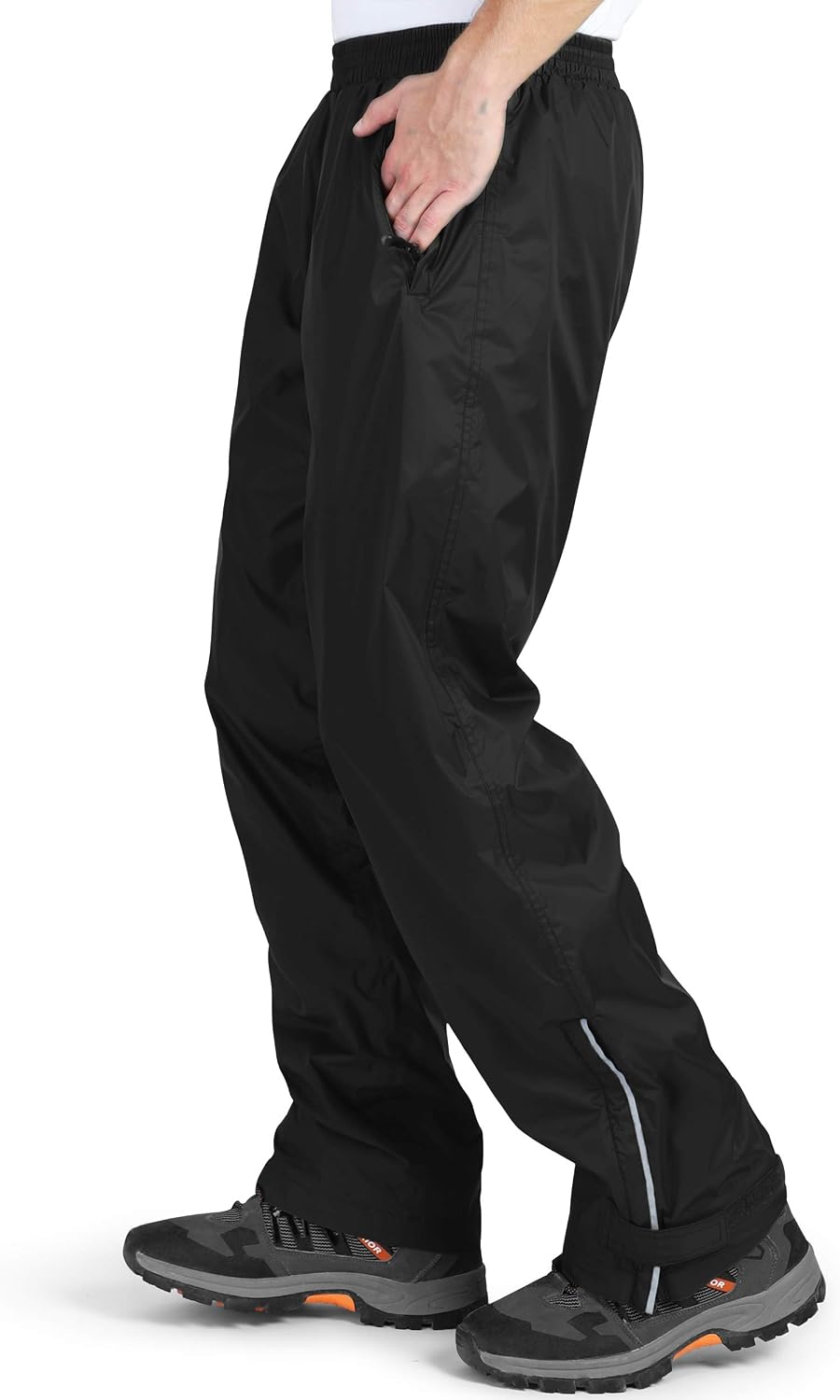 Side view of the black over trousers worn while walking, showing reflective piping and hiking boots
