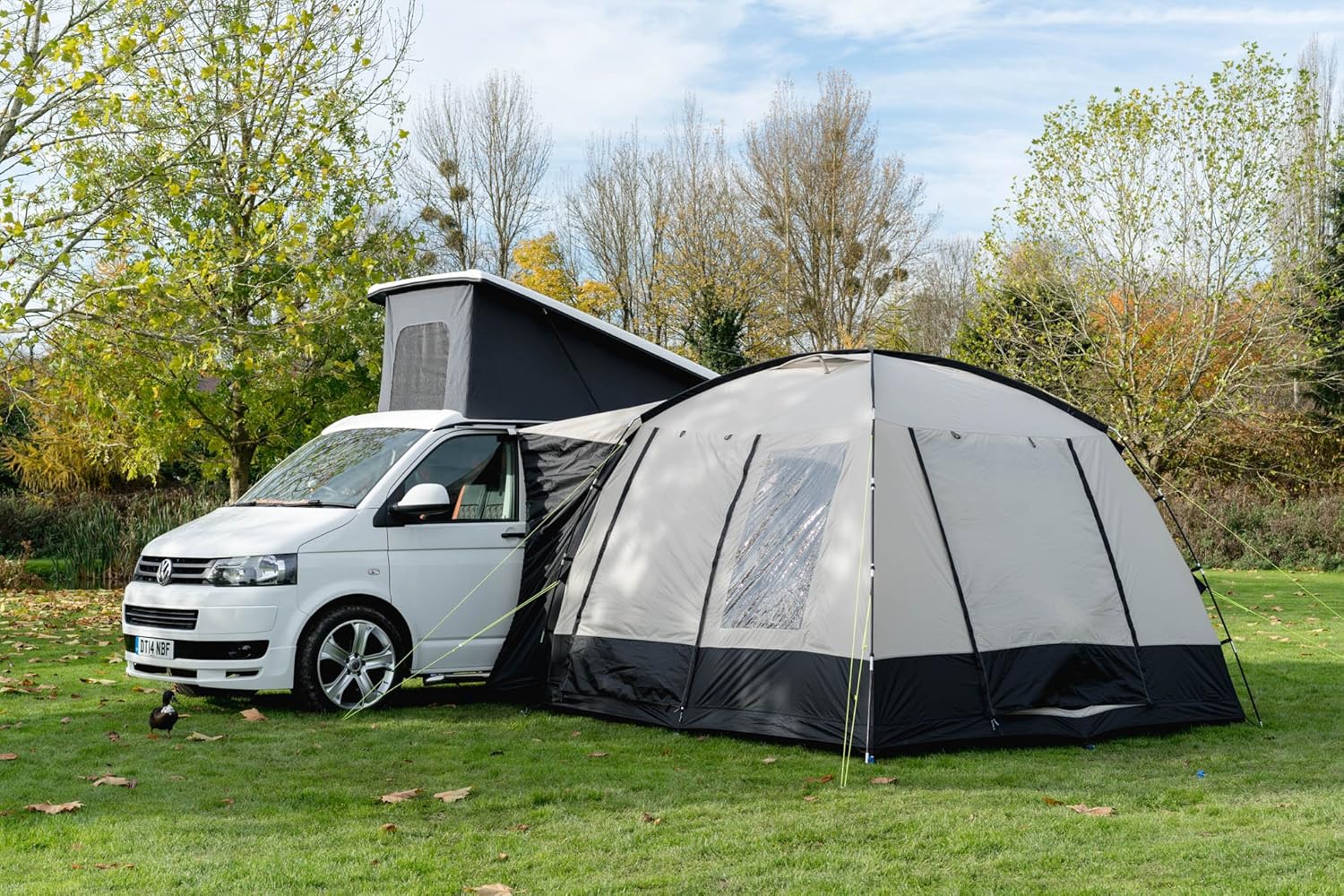 OLPRO Cubo V2 driveaway awning pitched alongside a white VW T5 pop-top campervan on a grass pitch