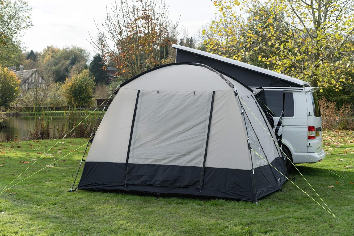 The Cubo V2 connected to the rear side door of a campervan with guy lines pegged out across grass