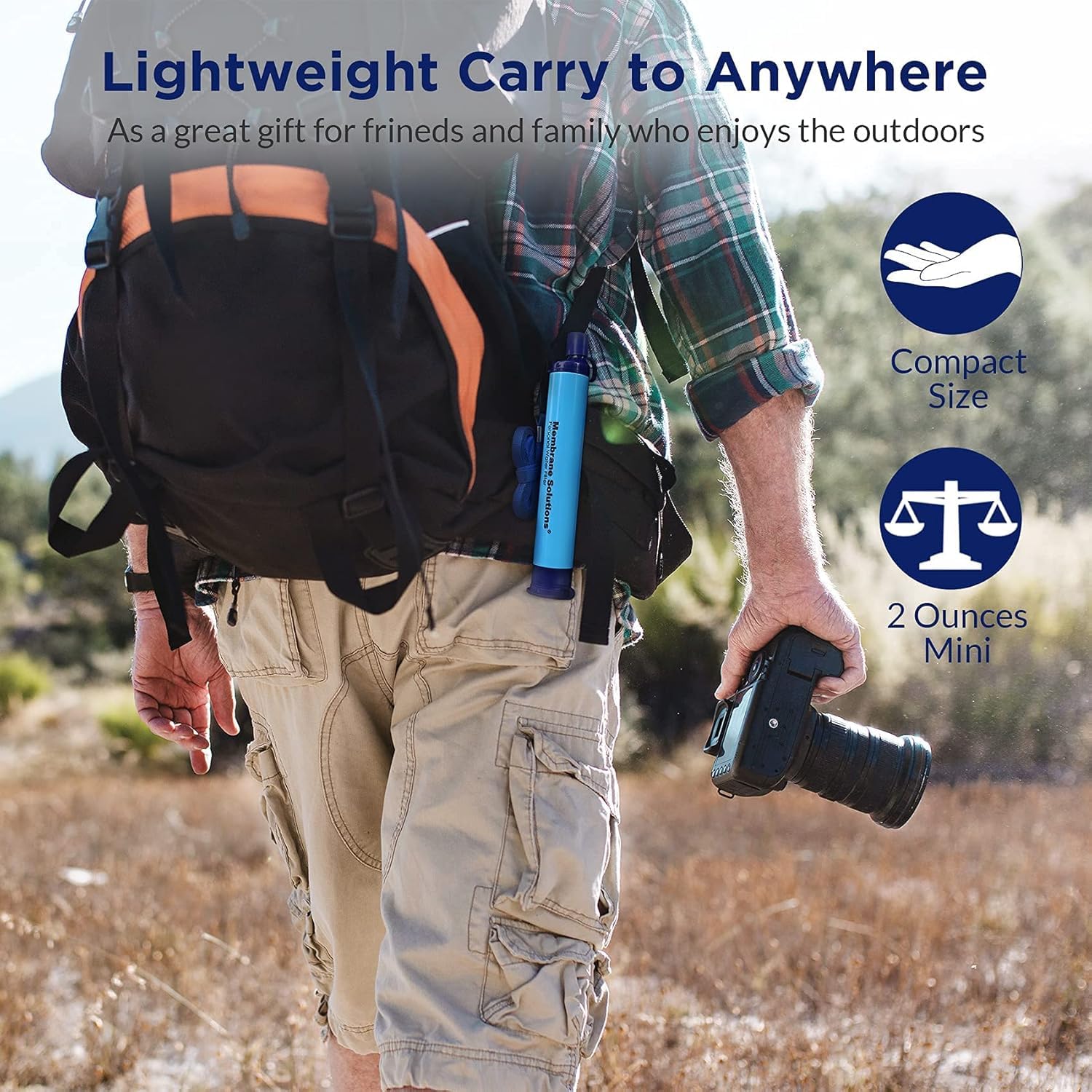 Filter straw clipped to a hiker's rucksack strap on an open trail