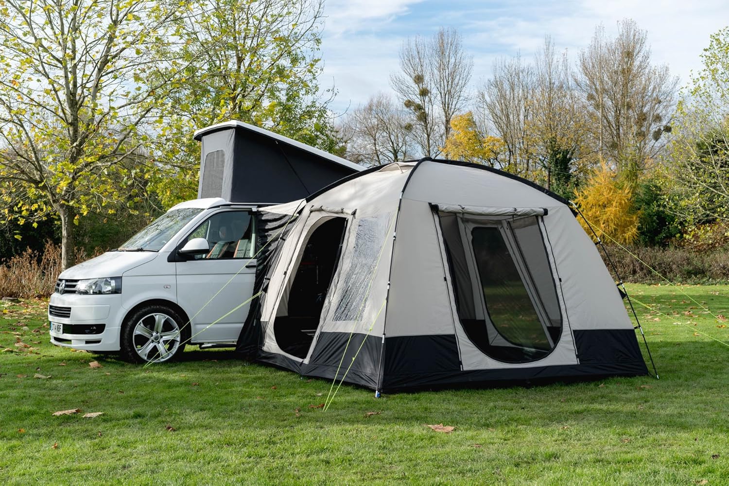 OLPRO Cubo V2 awning with its doors open next to a pop-top campervan on an autumn grass pitch