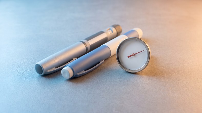 Insulin pens beside a plain temperature gauge showing the safe range to keep insulin cool while camping